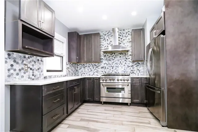 a kitchen with stainless steel appliances granite countertop wooden cabinets and a sink