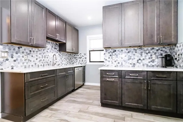 a kitchen with granite countertop a stove and a refrigerator with wooden floor
