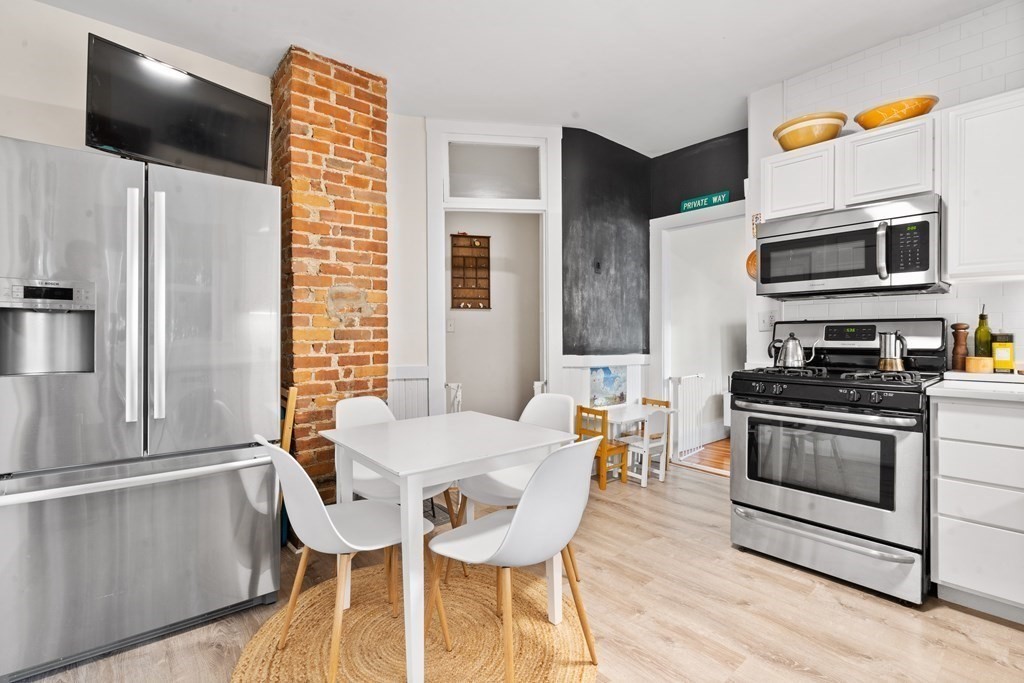 70 Montebello Road, Unit 1 Boston, MA 02130 - Photo 4 of 20 a kitchen with stainless steel appliances a microwave a stove and white cabinets
