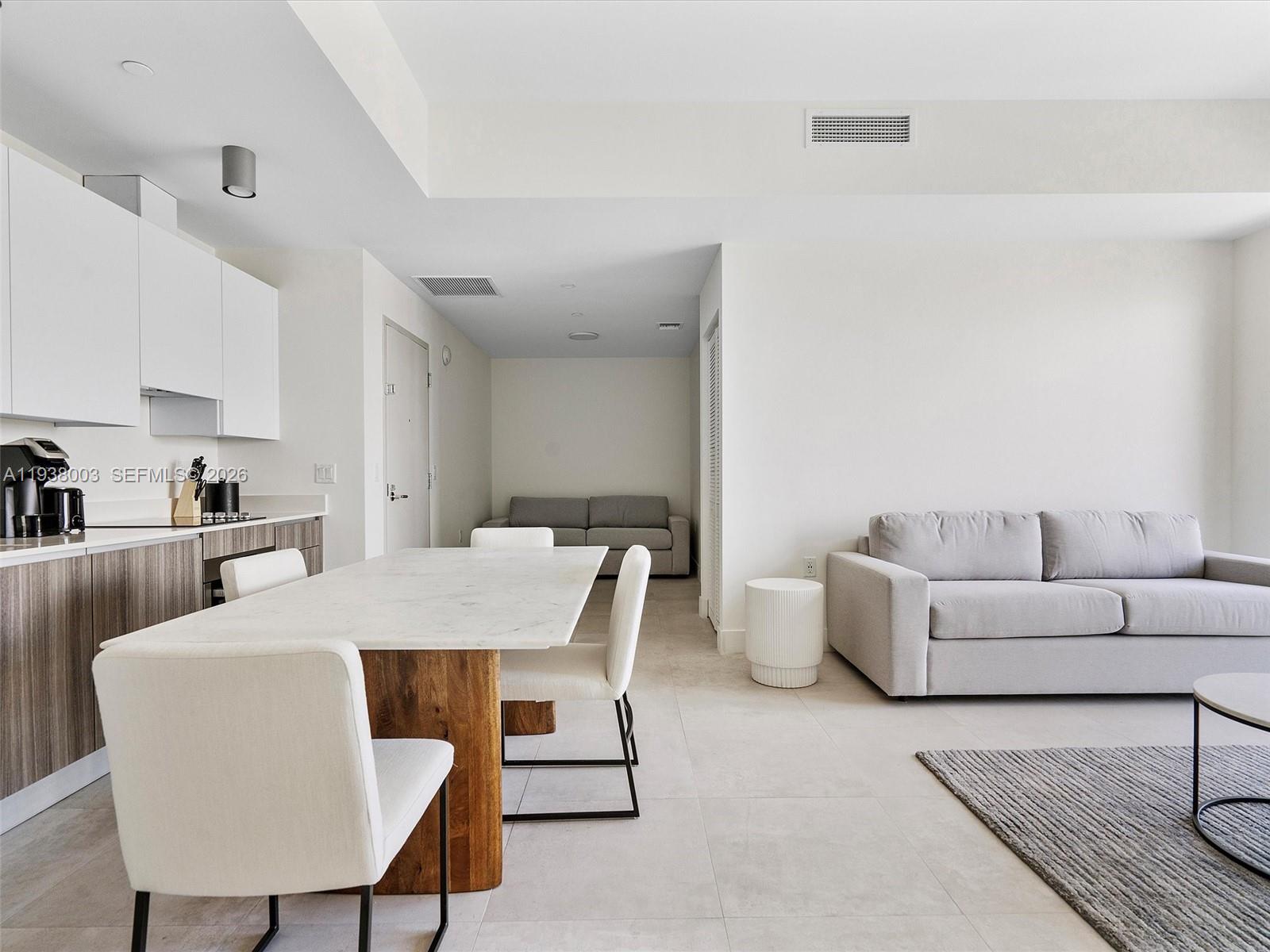 239 Southwest 9th Street, Unit 2003 Miami, FL 33130 - Photo 18 of 52 a living room with furniture a rug and a kitchen