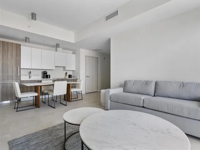 a living room with furniture and kitchen view
