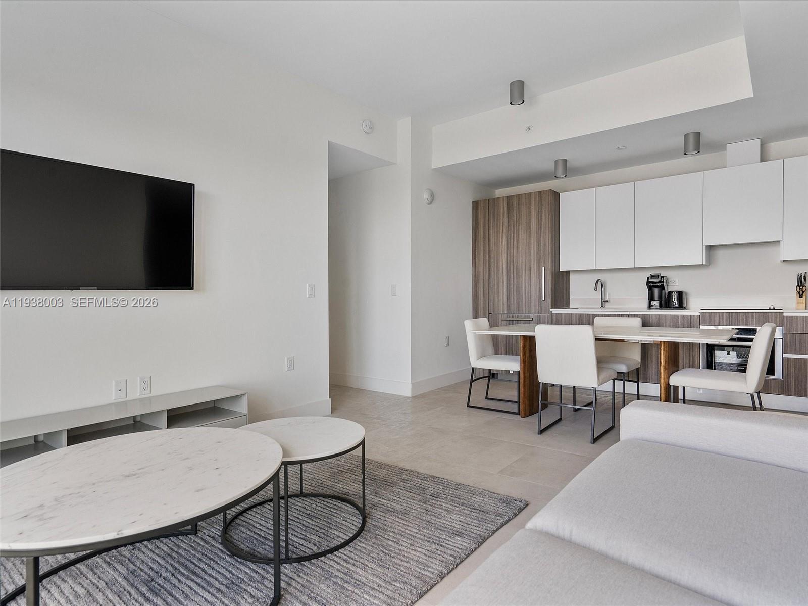 239 Southwest 9th Street, Unit 2003 Miami, FL 33130 - Photo 21 of 52 a living room with furniture a flat screen tv and kitchen view