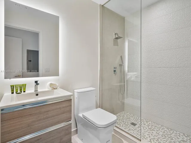 a large bed sitting in a bedroom next to a bathroom sink