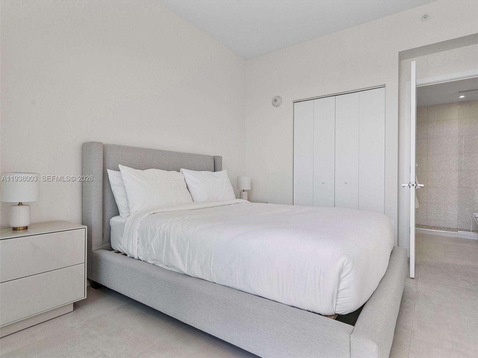 239 Southwest 9th Street, Unit 2003 Miami, FL 33130 - Photo 39 of 52 a large bed sitting in a bedroom next to a bathroom sink