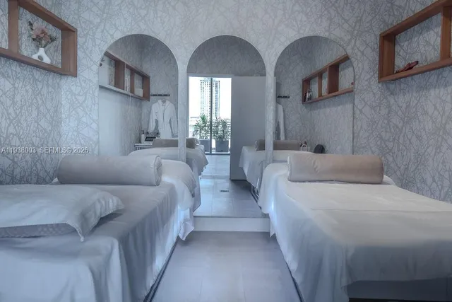 a bedroom with bed a mirror and the ceiling fan