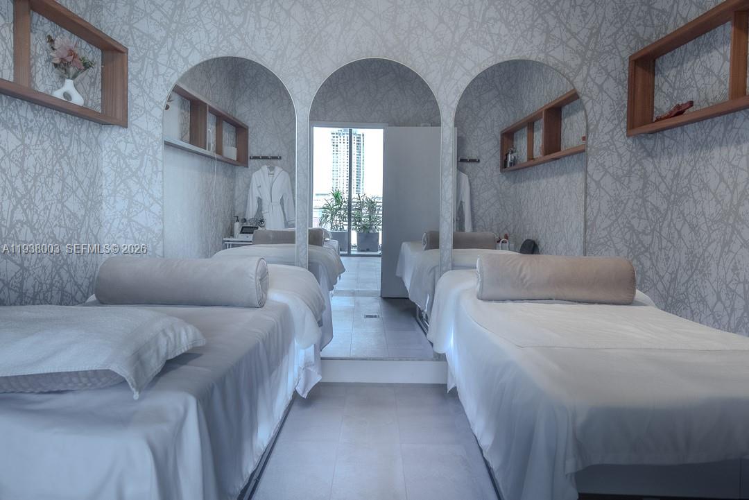 239 Southwest 9th Street, Unit 2003 Miami, FL 33130 - Photo 6 of 52 a bedroom with bed a mirror and the ceiling fan