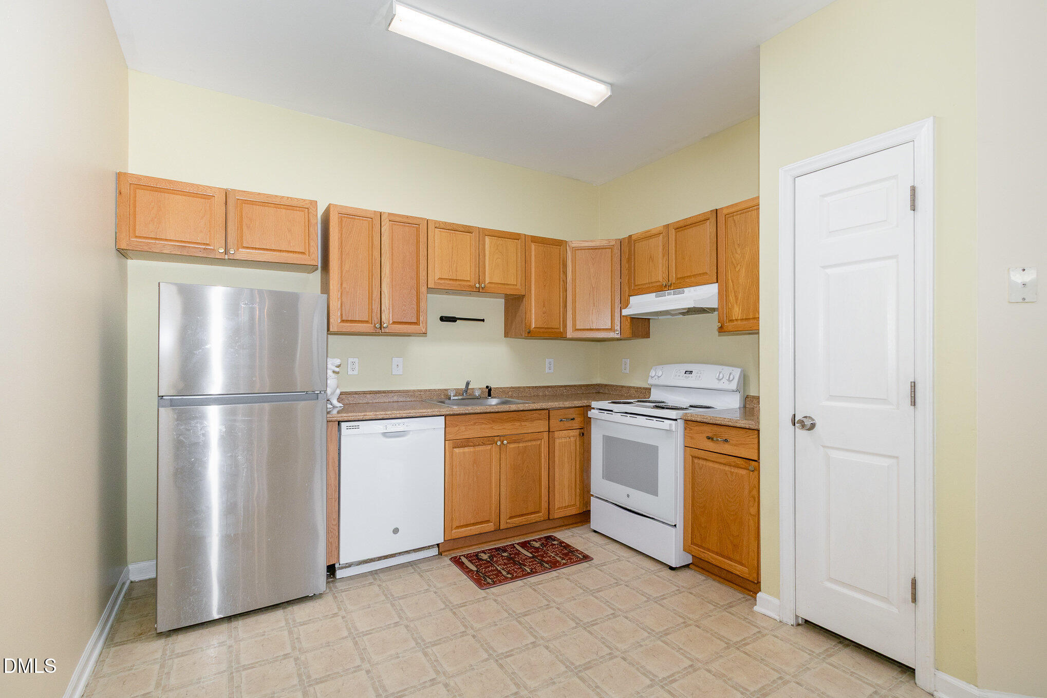 1311 Canyon Rock Court, Unit U105 Raleigh, NC 27610 - Photo 5 of 16 a kitchen with stainless steel appliances granite countertop a refrigerator and a stove top oven