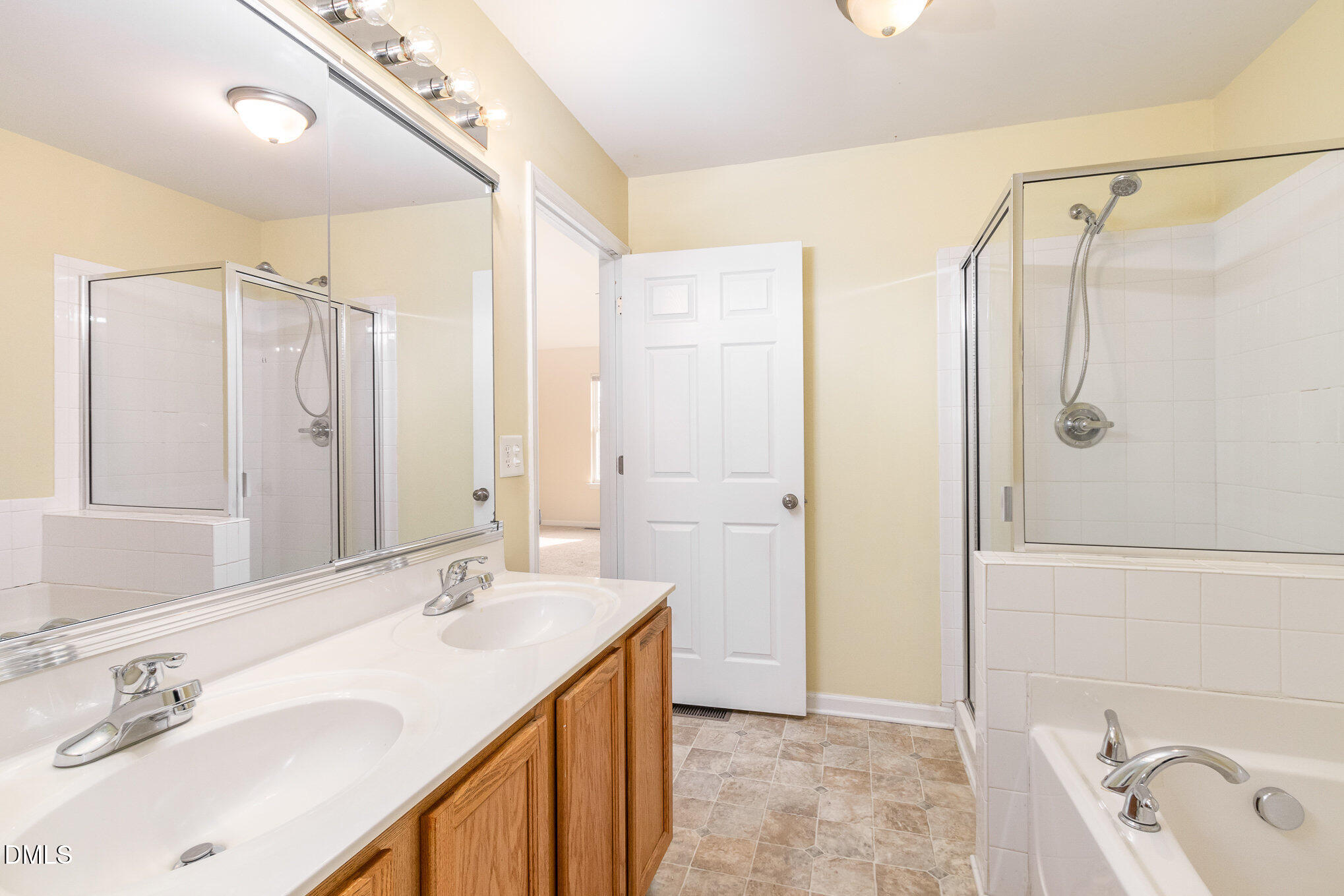 1311 Canyon Rock Court, Unit U105 Raleigh, NC 27610 - Photo 10 of 16 a bathroom with a granite countertop sink a mirror a shower and a bathtub