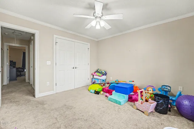 a bedroom with toys and a chandelier fan