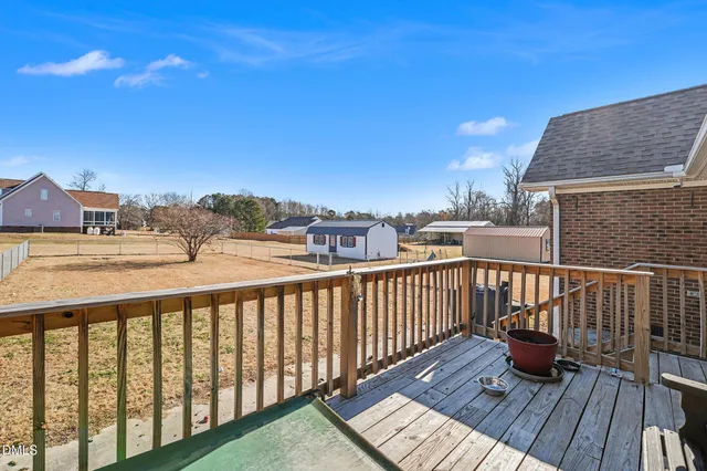 a view of a balcony with wooden floor and fence
