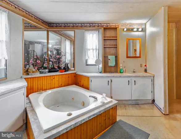 a large white tub sitting in a bathroom next to a window