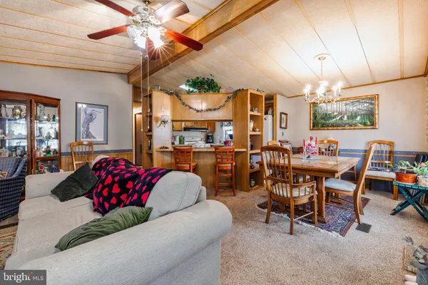 a living room with furniture a chandelier and a dining table