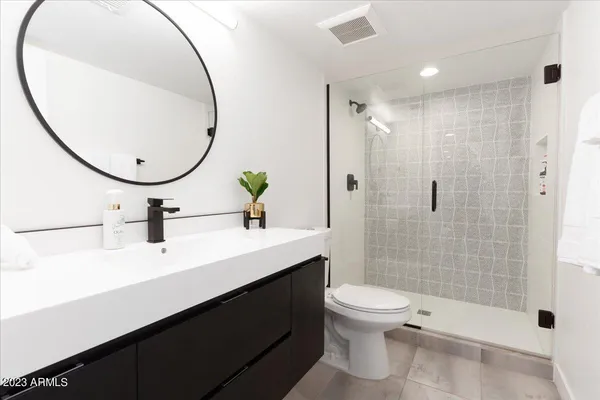 a bathroom with a sink a toilet and a mirror