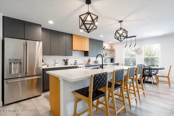 a kitchen with stainless steel appliances a table chairs refrigerator and microwave