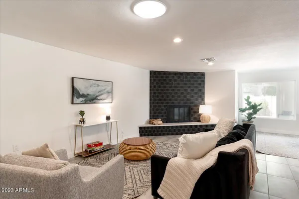 a living room with furniture a fireplace and a flat screen tv