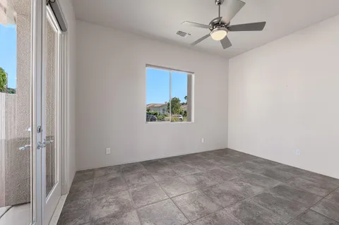 an empty room with fan and windows