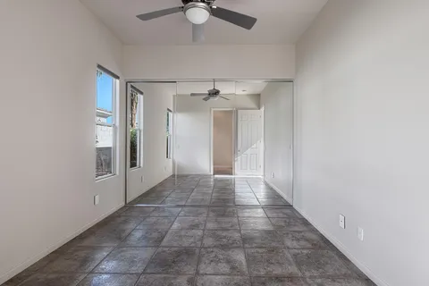 a view of a hallway with a chandelier fan and windows