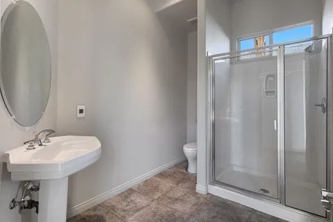 a bathroom with a sink a toilet and shower