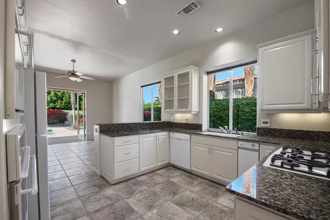 a kitchen with stainless steel appliances granite countertop a stove a sink and a refrigerator