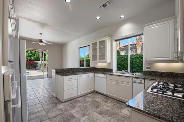 a kitchen with stainless steel appliances granite countertop a stove a sink and a refrigerator