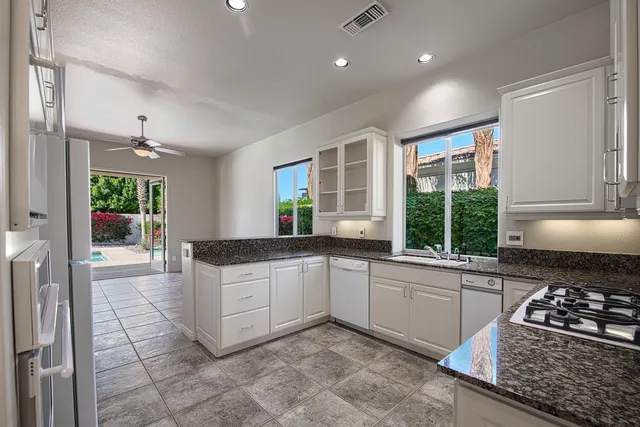 a kitchen with stainless steel appliances granite countertop a stove a sink and a refrigerator