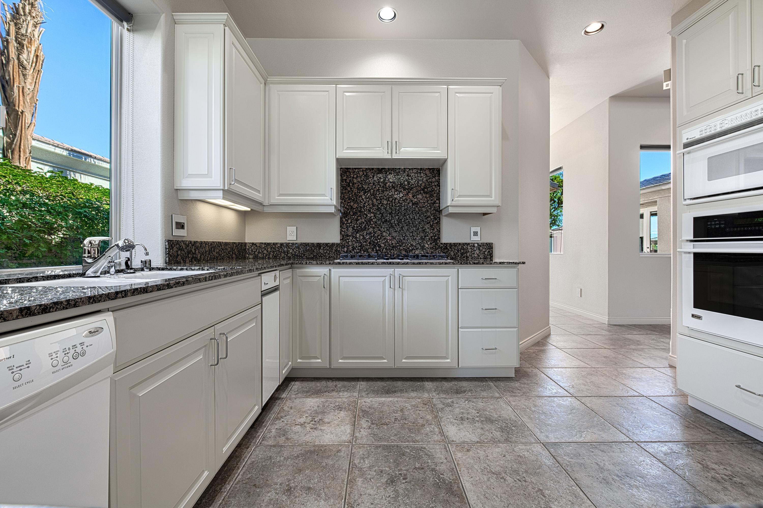 3 Cartier Court Rancho Mirage, CA 92270 - Photo 9 of 33 a kitchen with granite countertop a sink stainless steel appliances and cabinets