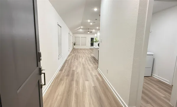 a view of a hallway with wooden floor and staircase