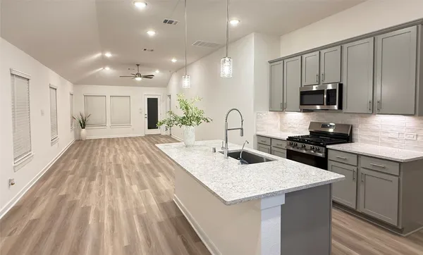 a kitchen with kitchen island granite countertop a sink and wooden cabinets