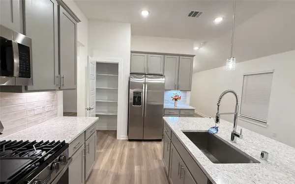 a kitchen with granite countertop a refrigerator and a sink