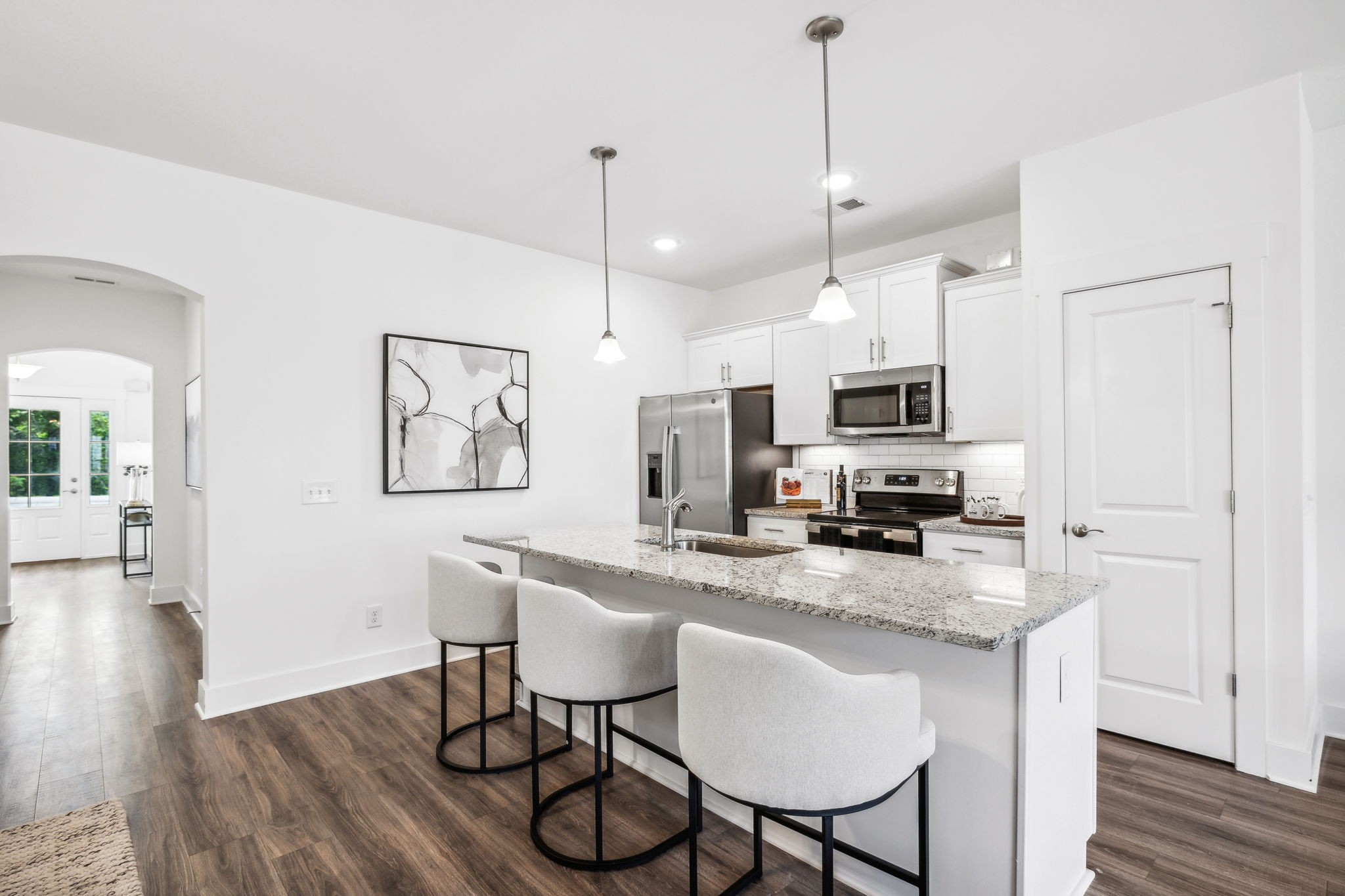 500 Black Tea Way Franklin, TN 37064 - Photo 12 of 68 a kitchen with stainless steel appliances granite countertop a stove a refrigerator a sink a dining table and chairs with wooden floor