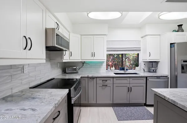 a kitchen with kitchen island granite countertop a sink stainless steel appliances and cabinets