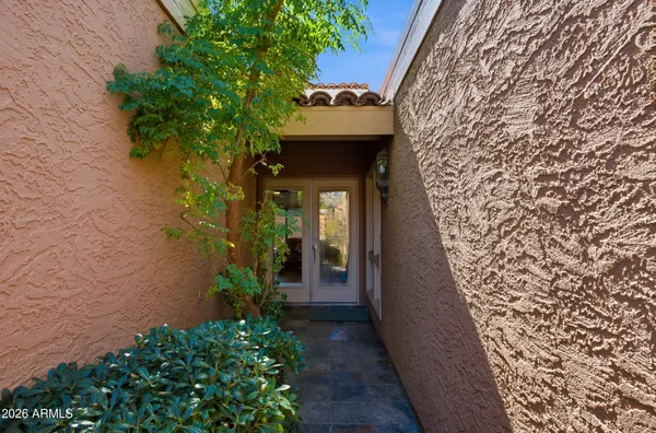 a view of a pathway of a house with potted plants