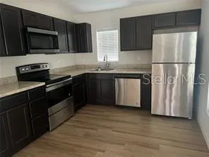 a kitchen with stainless steel appliances granite countertop a refrigerator and a stove top oven
