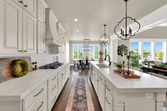 1132 South 1300th Street West Mapleton, UT 84664 - Photo 12 of 52 Kitchen featuring a gas range, range hood, and white cabinetry