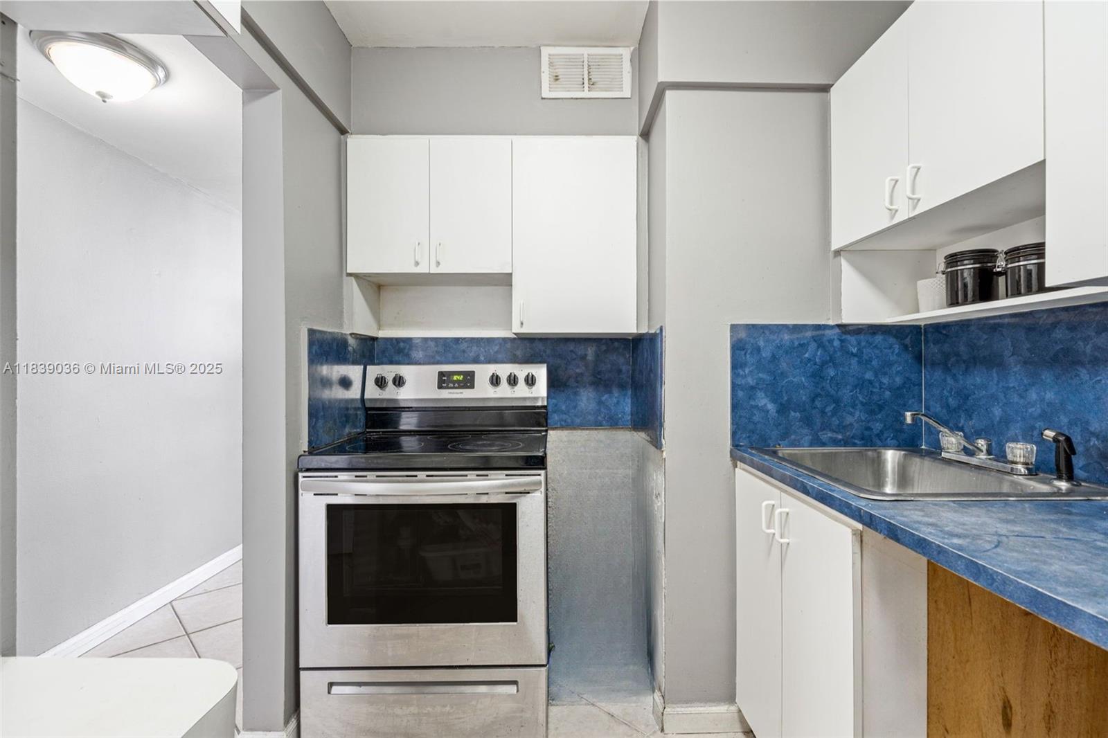 2899 Collins Avenue, Unit 931 Miami Beach, FL 33140 - Photo 15 of 28 a kitchen with sink a stove and cabinets