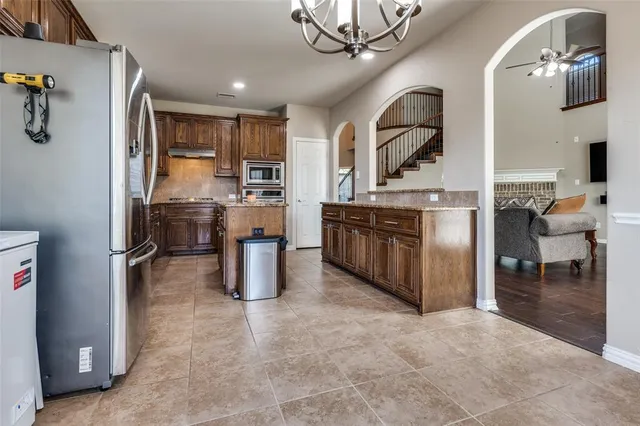 a kitchen with stainless steel appliances granite countertop a refrigerator and a stove