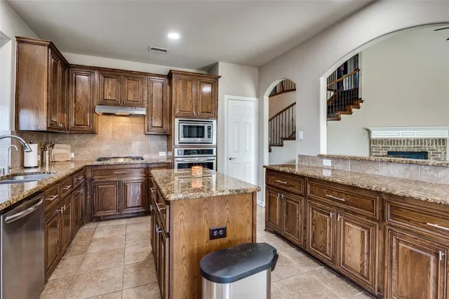 a kitchen with stainless steel appliances granite countertop a sink stove and cabinets