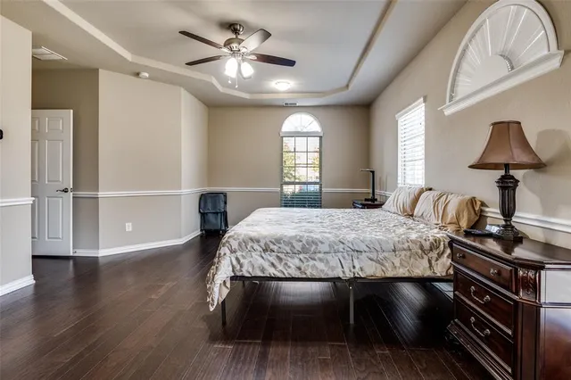 a spacious bedroom with a bed and a chandelier