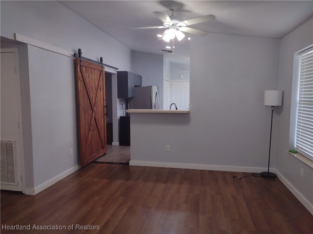 1731 West Batavia Road Avon Park, FL 33825 - Photo 5 of 25 an empty room with wooden floor and a ceiling fan