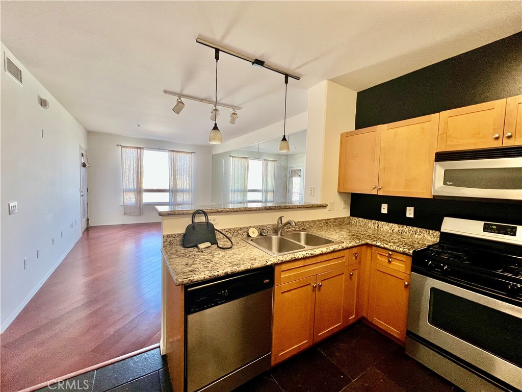 100 South Alameda Street, Unit 318 Los Angeles, CA 90012 - Photo 2 of 6 a kitchen with a sink stove and cabinets