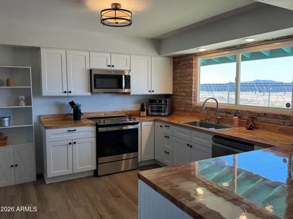 a kitchen with granite countertop a stove a sink and a microwave
