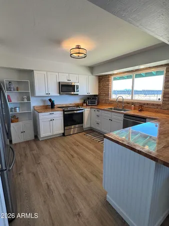 a kitchen with stainless steel appliances granite countertop a sink counter space cabinets and a window