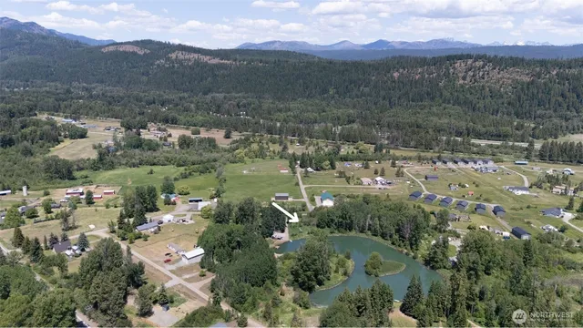 an aerial view of house with yard and mountain view in back
