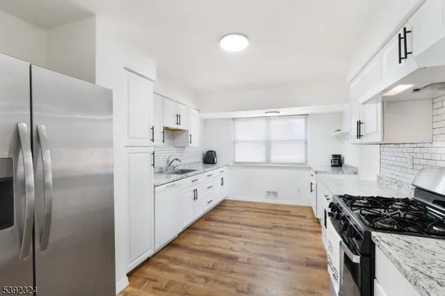 a kitchen with stainless steel appliances a refrigerator sink and stove