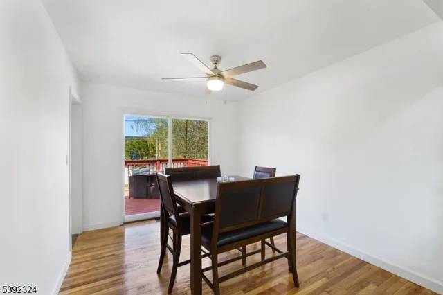 a view of a dining room with furniture a rug and wooden floor