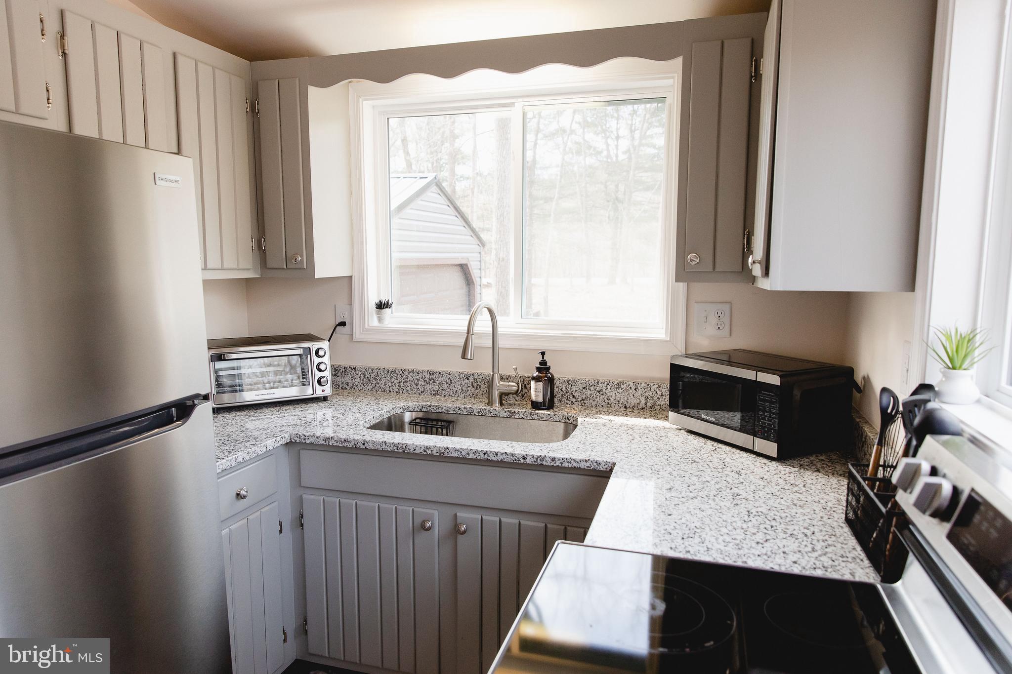 331 Walden Road Hedgesville, WV 25427 - Photo 9 of 30 a kitchen with granite countertop a sink stove and refrigerator
