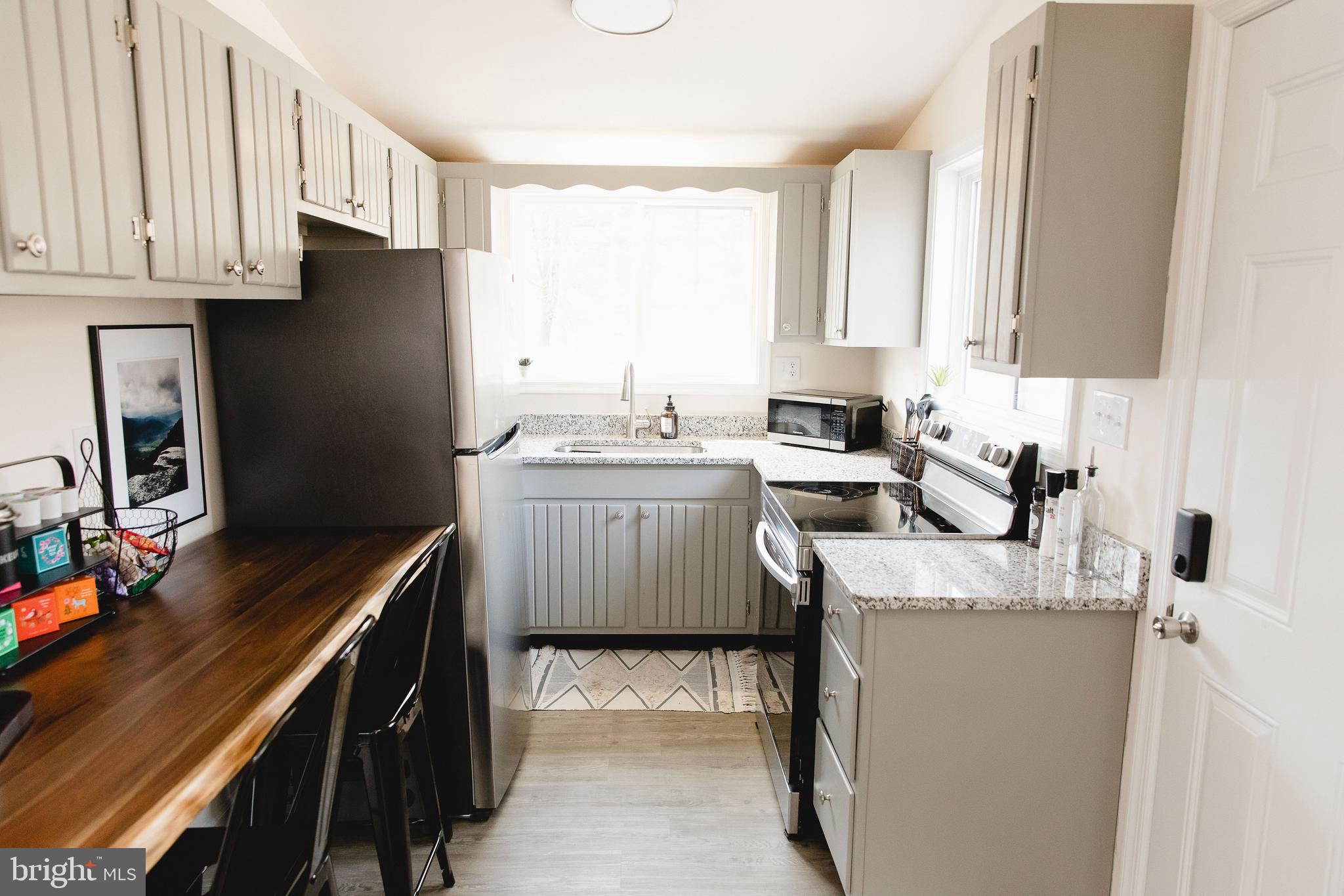 331 Walden Road Hedgesville, WV 25427 - Photo 10 of 30 a kitchen with stainless steel appliances granite countertop a sink stove and refrigerator