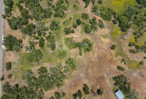 an aerial view of residential houses with outdoor space and trees
