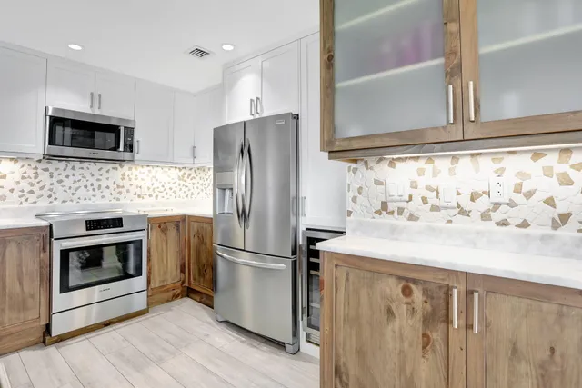 a kitchen with stainless steel appliances a refrigerator sink and microwave