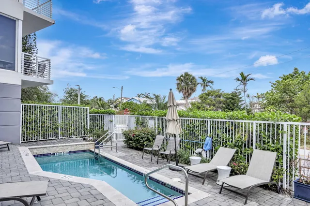 a balcony with wooden floor table and chairs